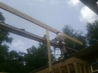 Carpenter setting a ridge beam over a new addition frame — Ice Dam Removal by Roofing Brothers in Jerseyville