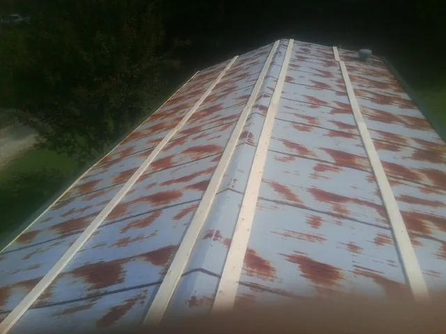 Rusted metal roof panels with new wood purlins before replacement — Storm Damage Roof Repair in Jerseyville by Roofing Brothers