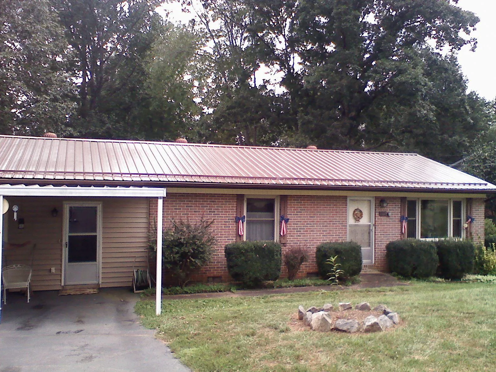 Bronze metal roof and carport on a brick ranch home — Roof Repair work by our crew in Jerseyville